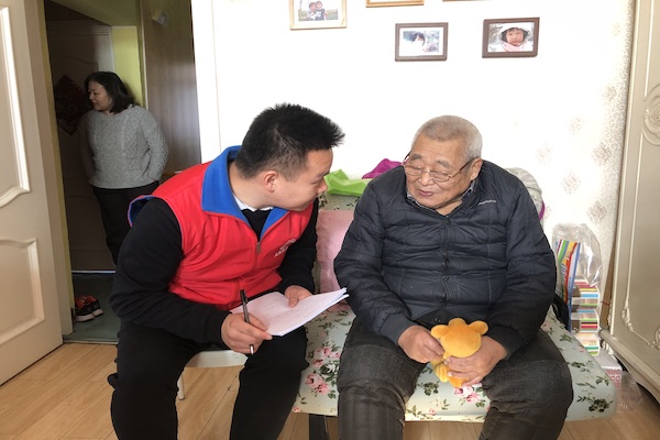 Two men, one elderly and one young, talk.