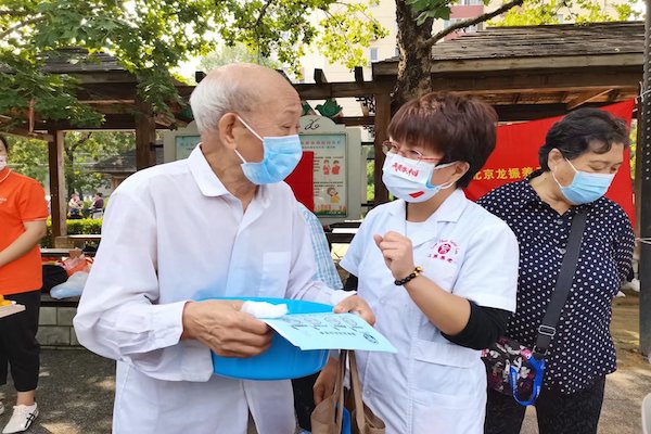 Two elderly people with masks on talk.