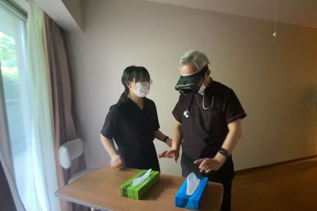 A woman talking to a man wearing an AR headset and looking at two differently colored boxes of tissues