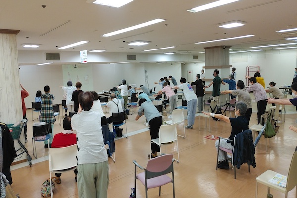 Elderly people stretch at a class.