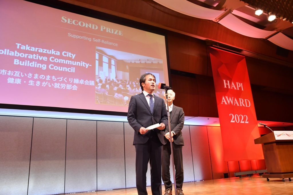 Mr. Toshiaki Onza, Chairman of the NGO SPICE Works Lab and Mr. Takehiro Morikawa, Director of the Community Welfare and Services Division of Takarazuka-City accepted the Second Prize for Supporting Self-Reliance